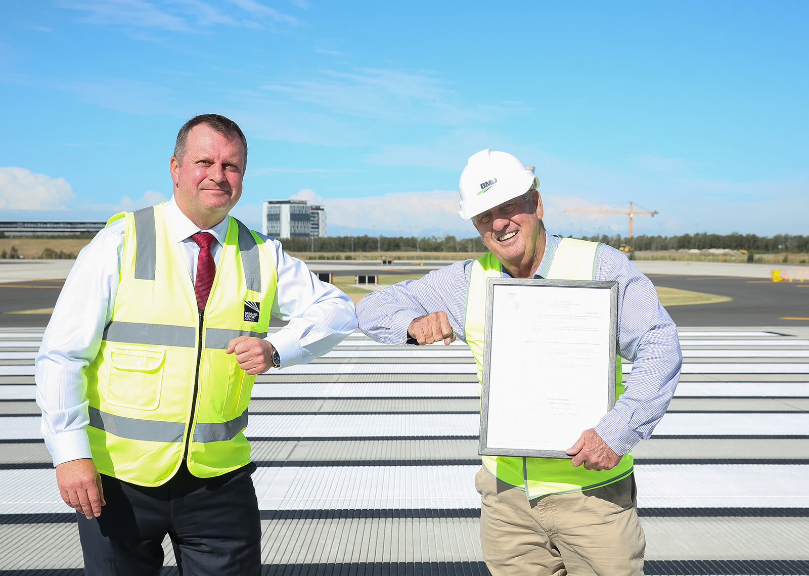 Gert-Jen de Graaff and Mick Power celebrate the practical completion of the new runway