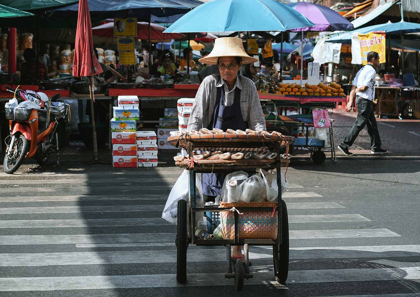 A fishmonger pedalling her food trike in the streets of Bangkok, Thailand