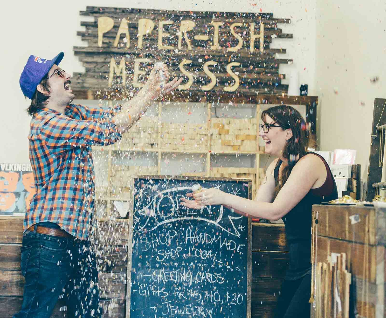 Lisa and Sean Murty throw paper confetti in the air at Paperish Mess, Chicago | See Chicago like a local