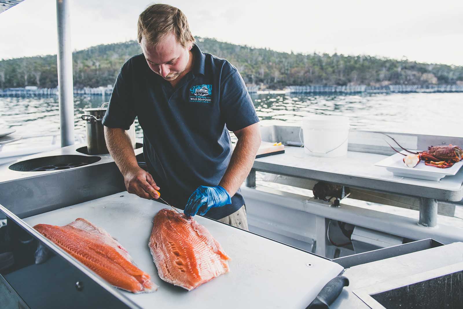 Filleting fresh salmon on board a Tasmanian Wild Seafood Adventures tour | Seafood safari in Tasmania