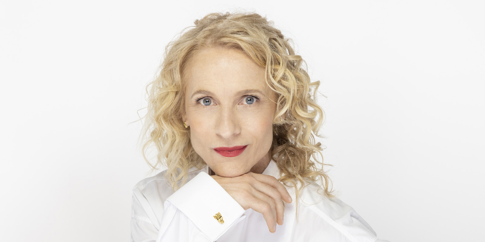 headshot of blond curly haired lady in white shirt 