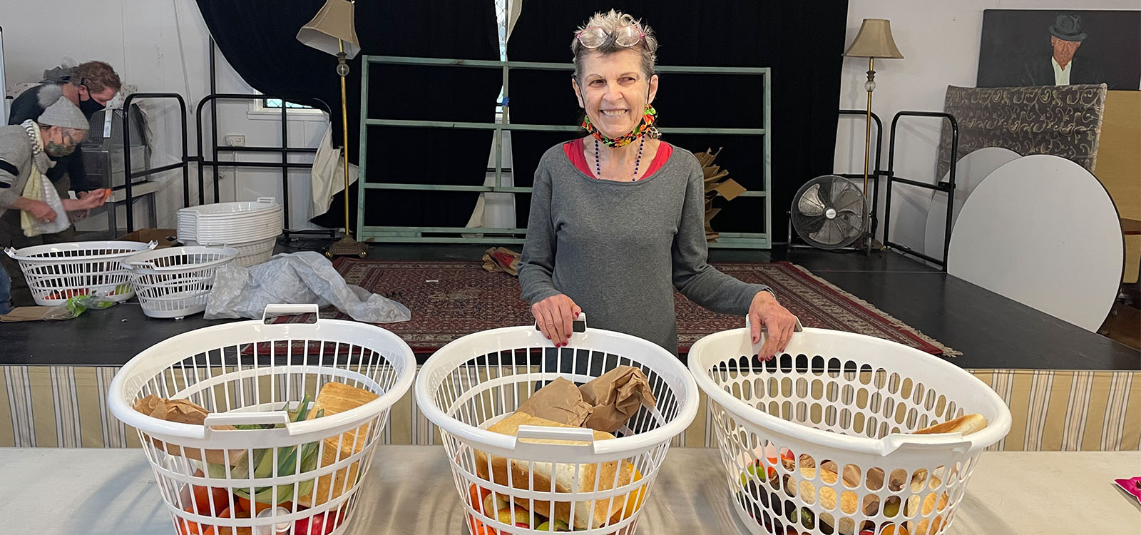 SANDBAG volunteer Gwen standing behind baskets of fresh food and bread 