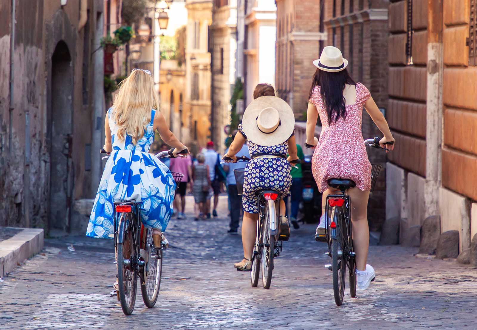 Girls riding bikes through the streets of Rome | Why slow travel is gaining momentum