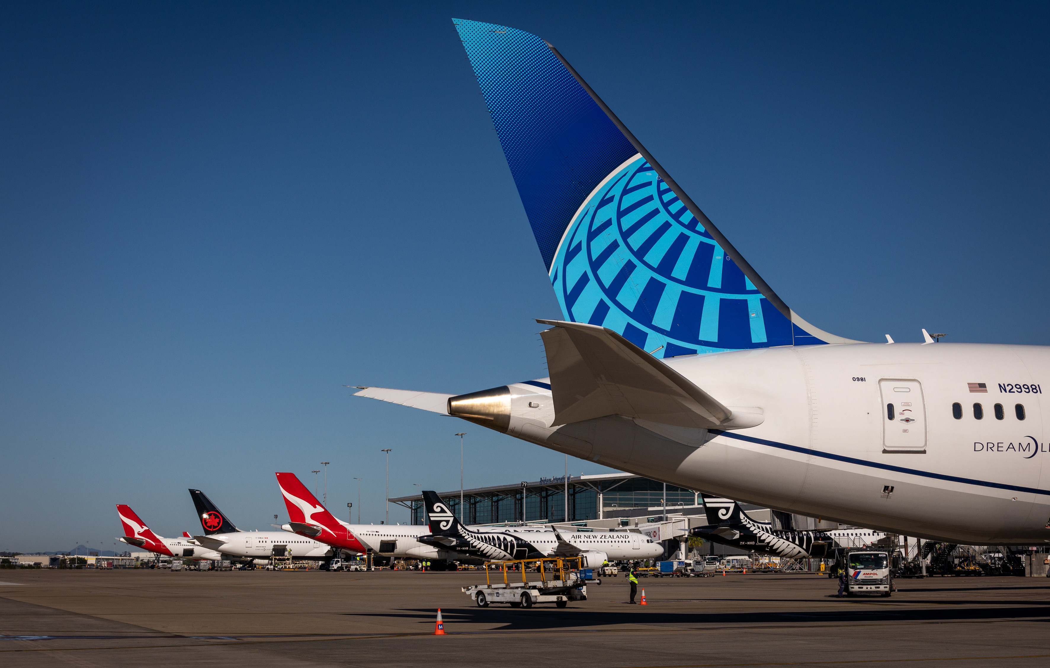 United Airlines plane tail in the front with three planes in the background United Airlines plane tail in the front with three planes in the background