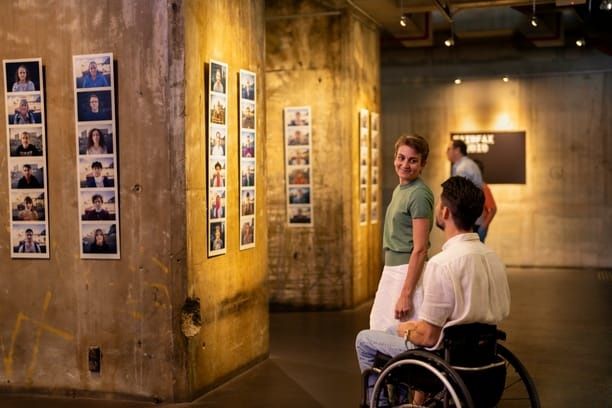 Lady and man in wheelchair looking at photos at Brisbane Powerhouse