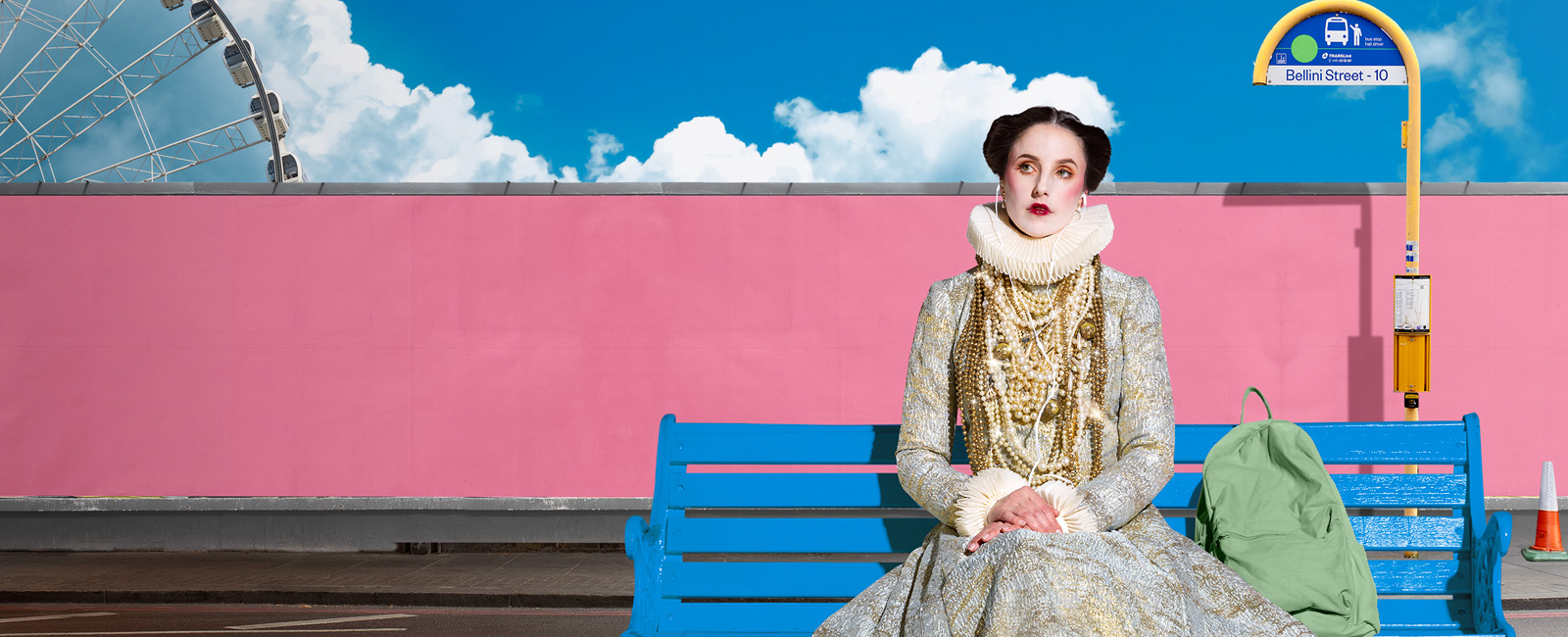 Lady in opera attire sitting on a blue bench