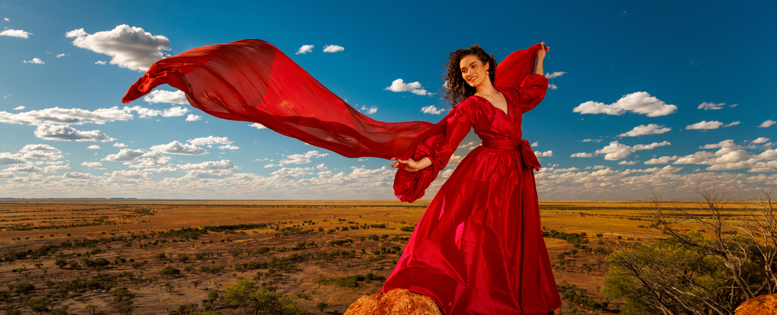 A women in a red dress in the outback