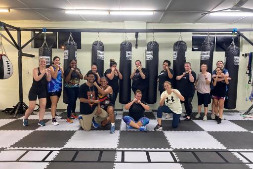 group of boxes posing in front of punching bags