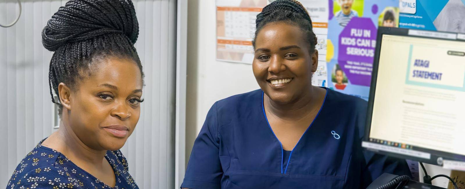 A women and a nurse sitting at a desk