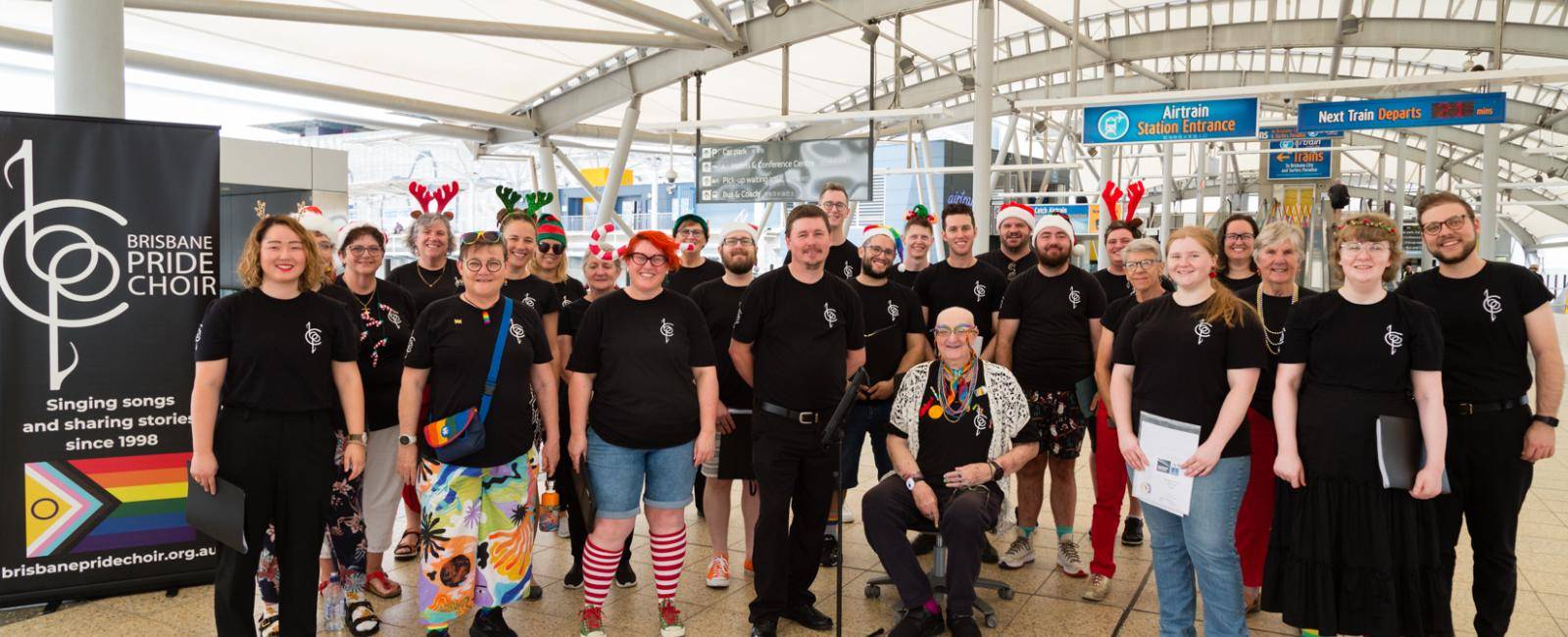 The Brisbane Pride Choir standing on the skywalk at Brisbane Airport