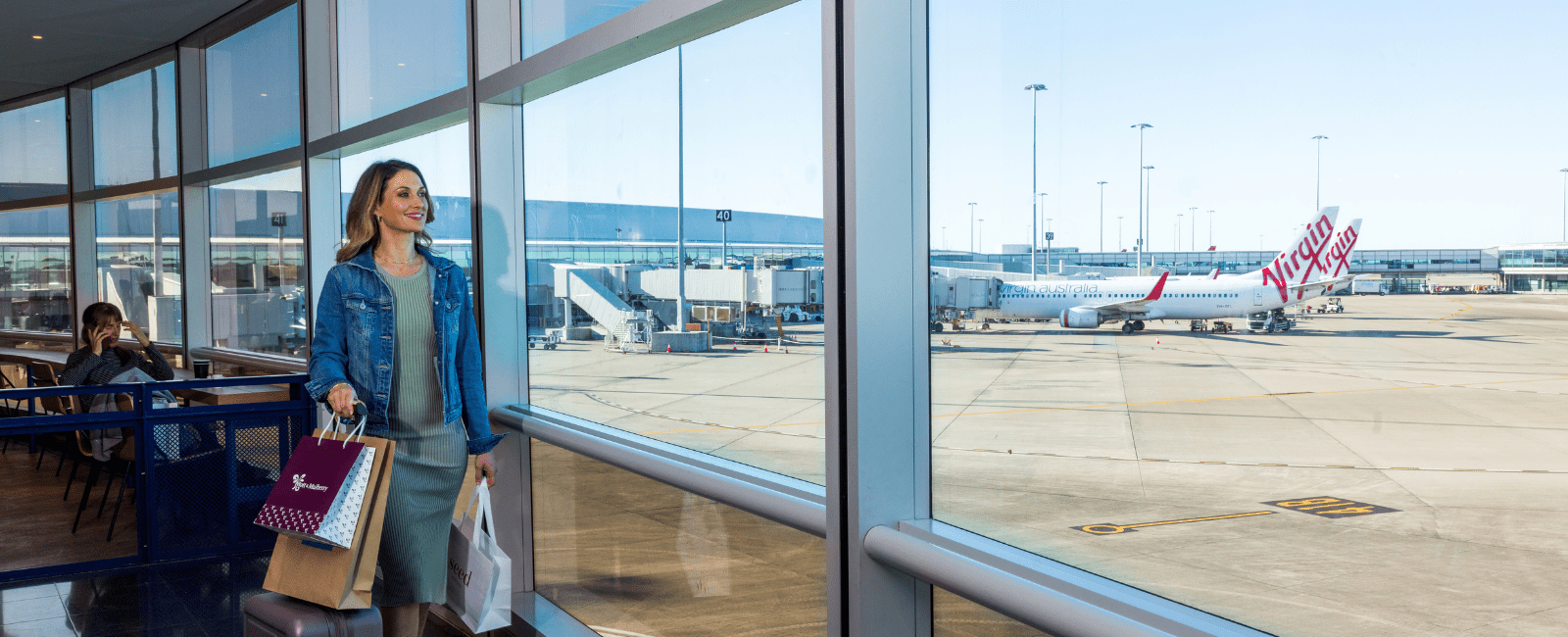 Person with shopping bags looking at runway