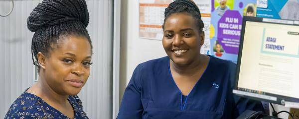 A women and a nurse sitting at a desk