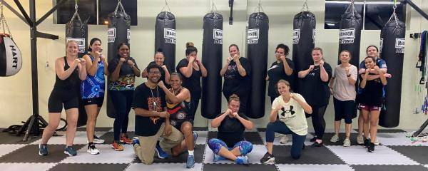 group of boxes posing in front of punching bags