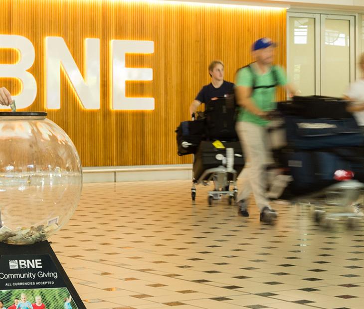 Passenger donating money to a Charity Giving Globe at the International Terminal Passenger donating money to a Charity Giving Globe at the International Terminal