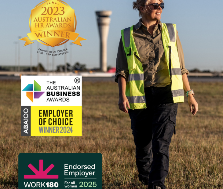 An airside operations officer walking with the air traffic control tower in the background An airside operations officer walking with the air traffic control tower in the background