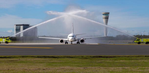 First plane on the new Brisbane Runway with fire trucks shooting water cannons to welcome it