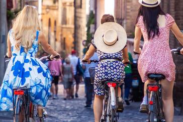 Girls riding bikes through the streets of Rome | Why slow travel is gaining momentum