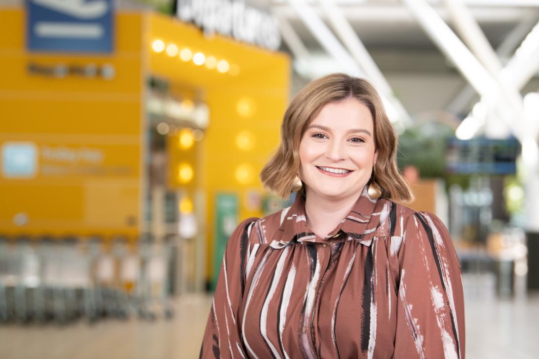 Maddison standing in front of the departures sign