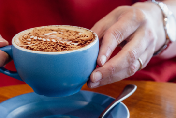 Person holding coffee at Coretto Cafe & Bar