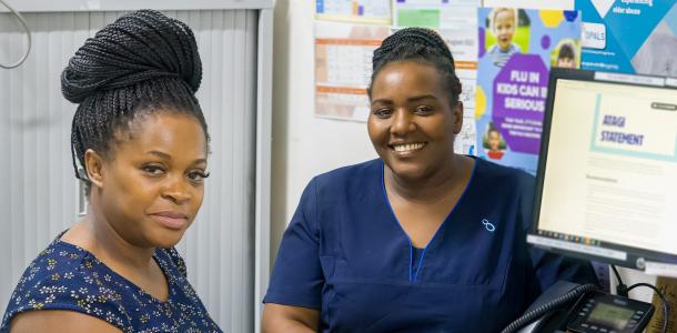 A women and a nurse sitting at a desk