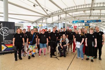 The Brisbane Pride Choir standing on the skywalk at Brisbane Airport