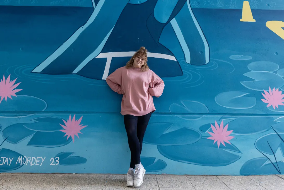 Tori-jay Mordey standing in front of her Enoggera Reservoir artwork