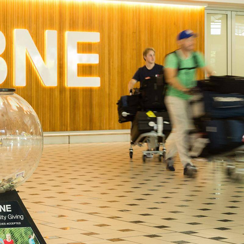 Passenger donating money to a Charity Giving Globe at the International Terminal Passenger donating money to a Charity Giving Globe at the International Terminal