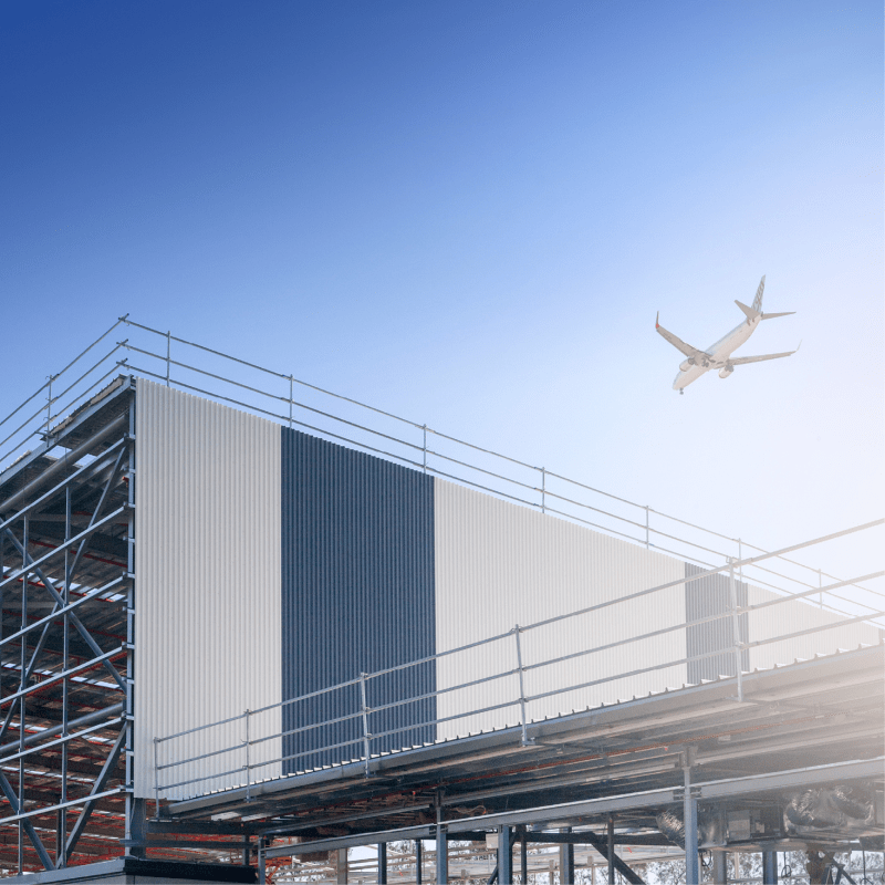 Plane flying over building - Brisbane Airport